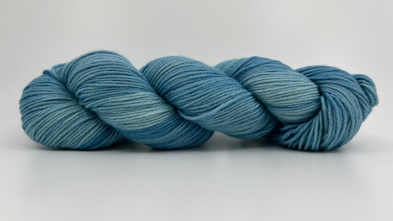 A skein of Wonderland Yarns Alice DK in colorway Cloudland