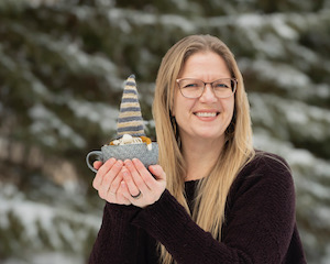 Sarah Schira holding one of her handknit gnomes